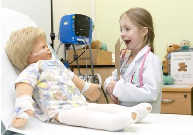 Child dressed as a doctor with doll patient