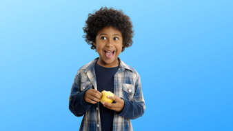 Photo of a happy looking young child eating an apple